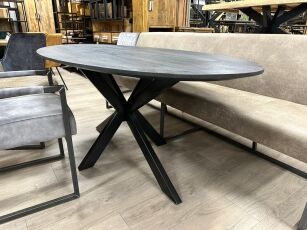 Esszimmertisch aus ovalem Mangoholz mit schwarzem Finish und facettierter Kante aus Massivholz.