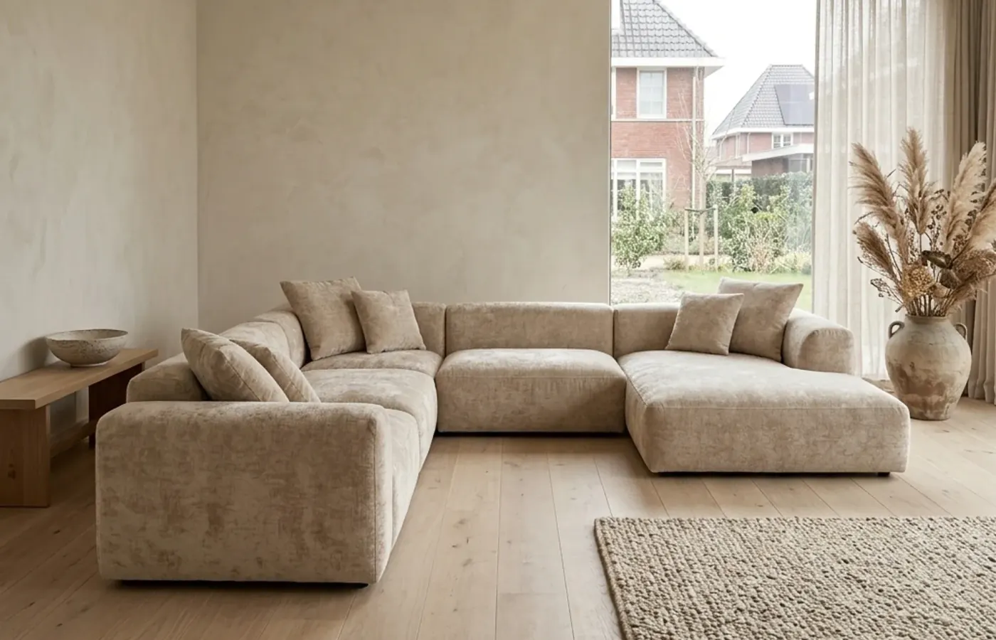 Beiges Elementsofa Body von Primavera in einem hellen Wohnzimmer mit großer Fensterfront